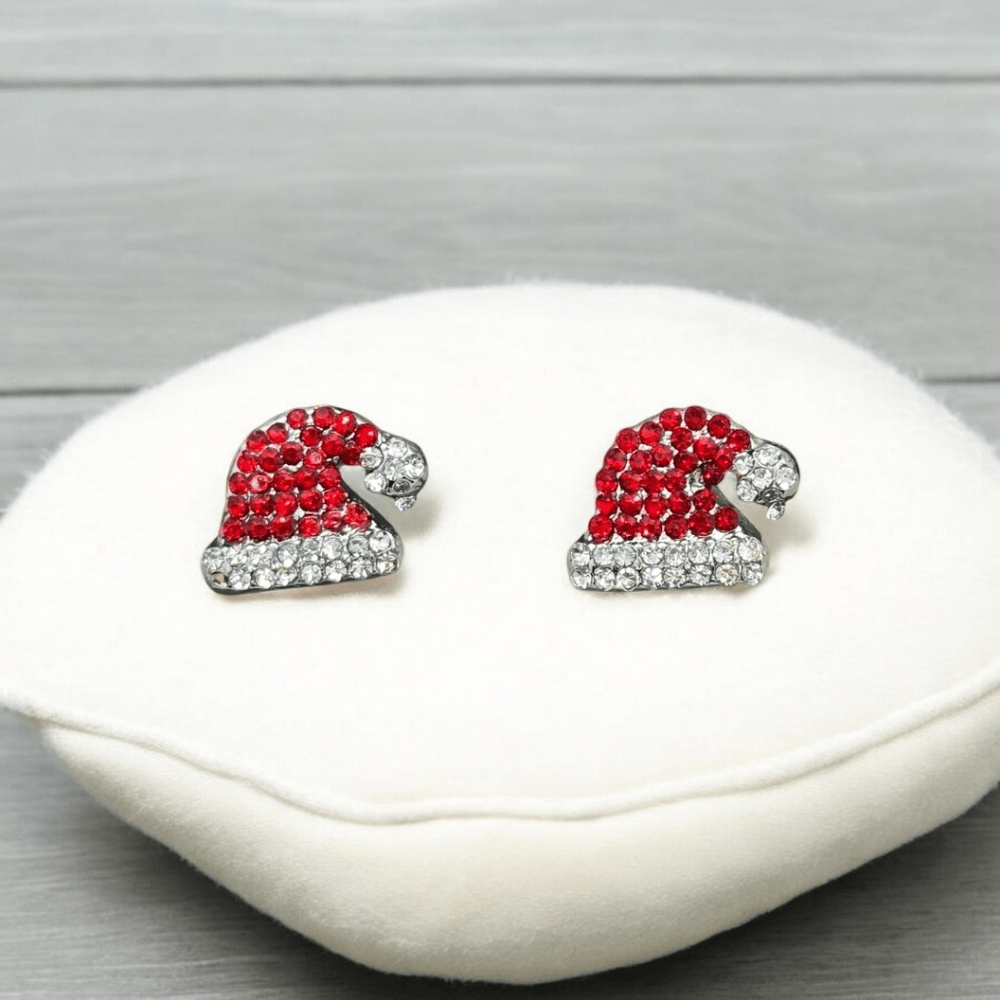 Santa Hat Rhinestone Earrings with clear stones on a white cushion