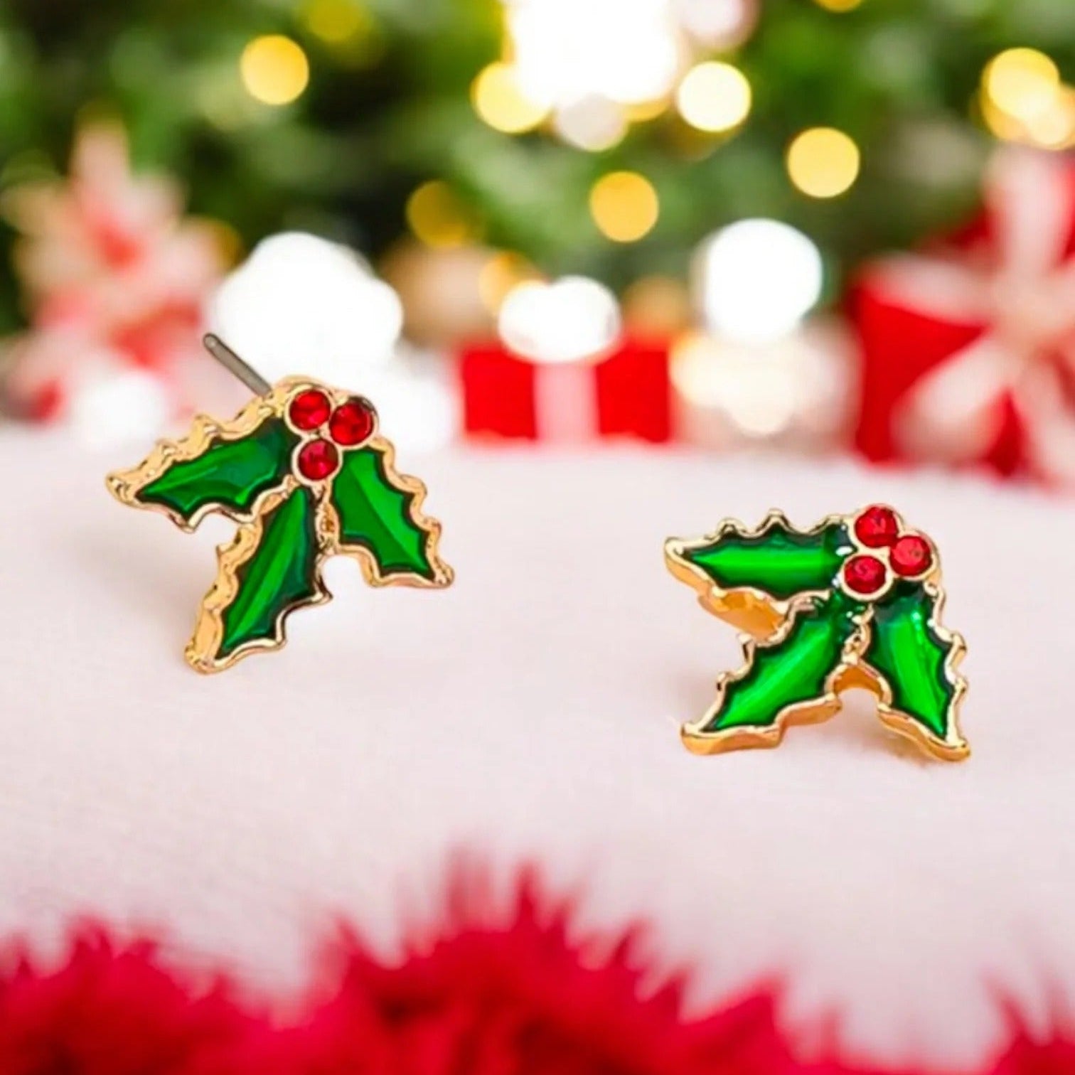 Red Berry Holly Earrings with red berries on a festive background with Christmas tree and presents.