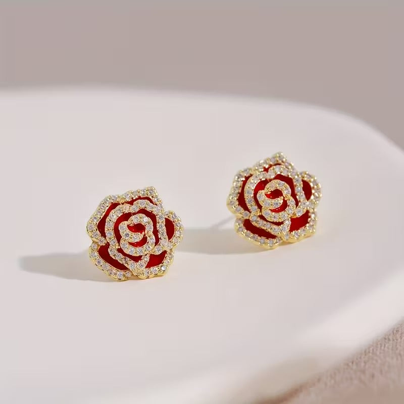Rhinestone Rose Earrings with gold accents on a light surface