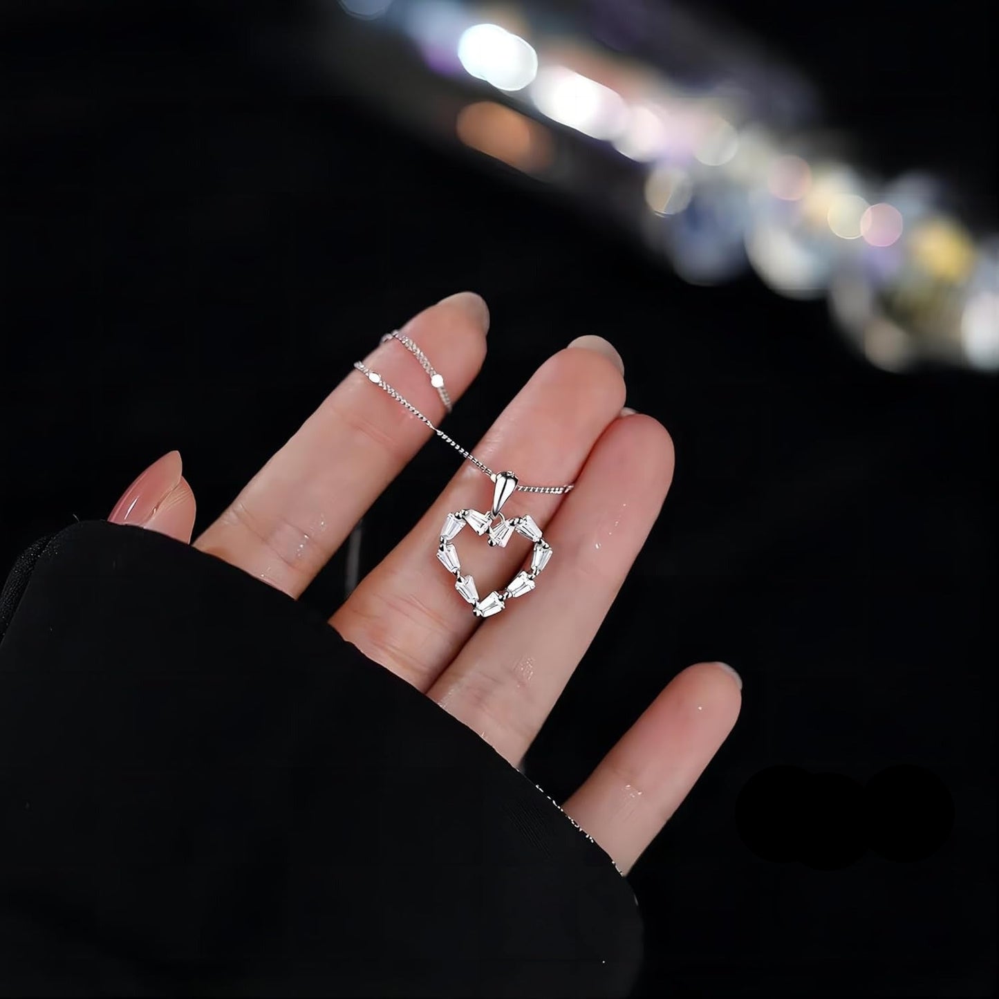 Silver Crystal Heart Necklace on a blurred night cityscape background