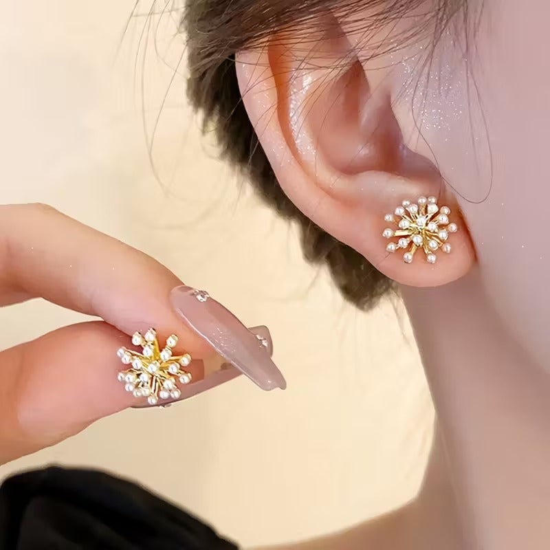 Close-up of a person wearing Gold Burst Pearl Earrings with a blurred background