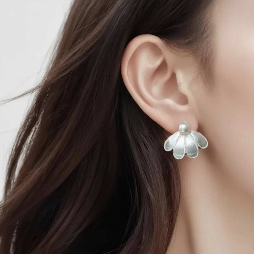 Silver Sculpted Petal Pearl Earrings worn by a person with long dark hair.