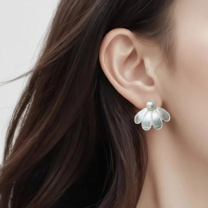 Silver Sculpted Petal Pearl Earrings worn by a person with long dark hair.