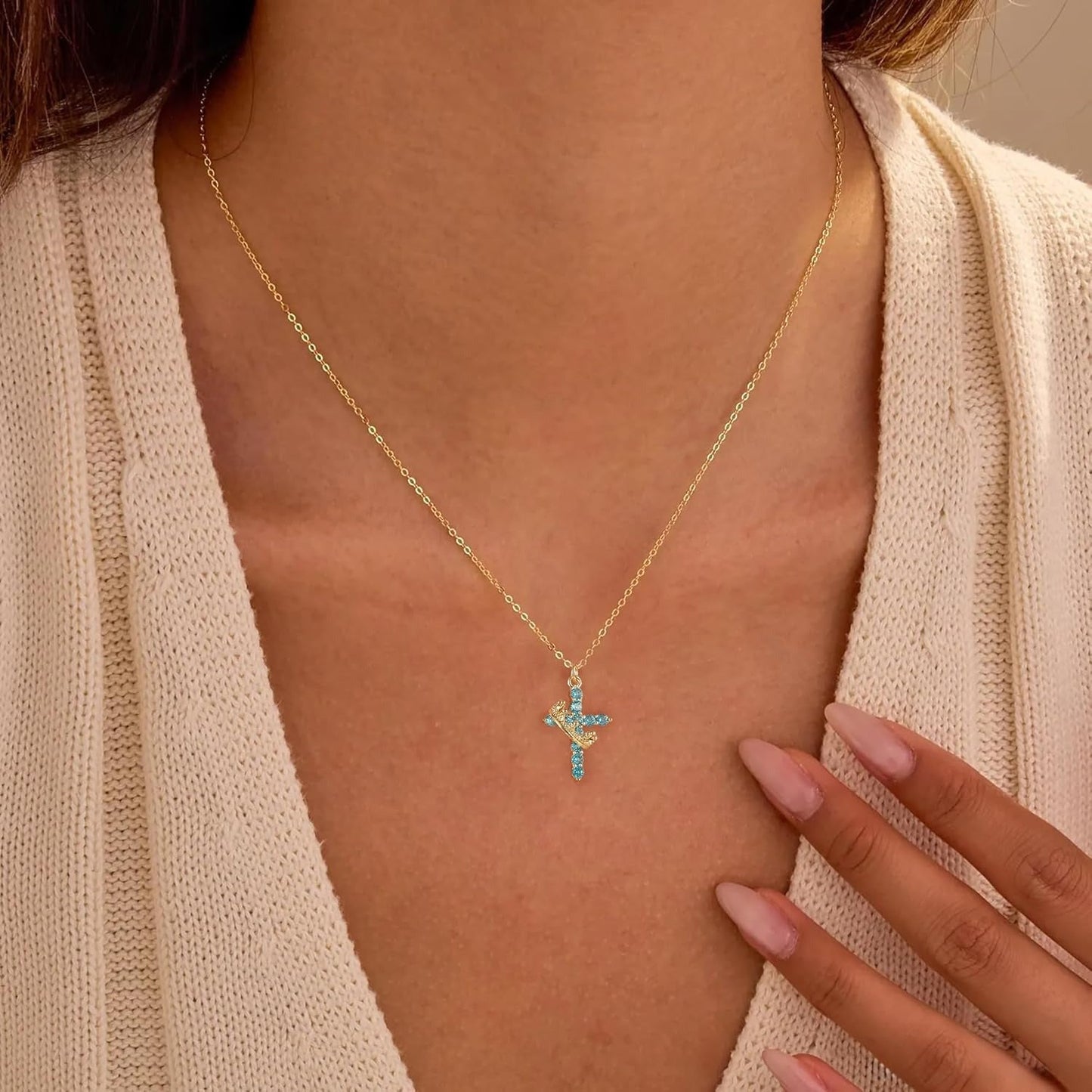 Blue & Gold Crown Cross Faith Necklace worn by a person wearing a beige cardigan.