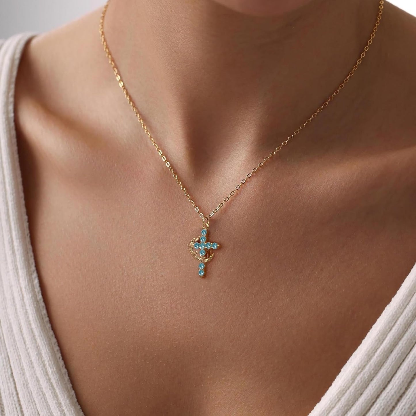 Blue & Gold Crown Cross Faith Necklace on a person wearing a white top.