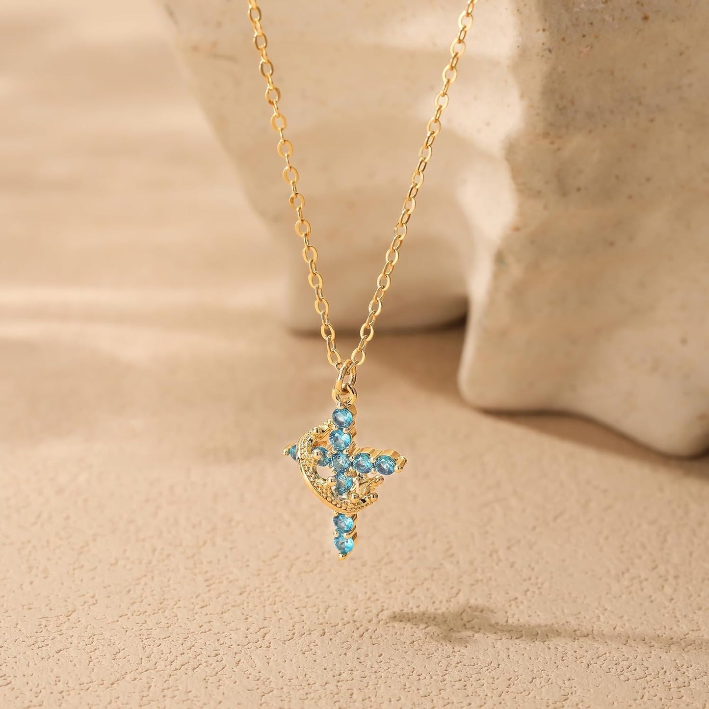 Blue & Gold Crown Cross Faith Necklace on a beige background
