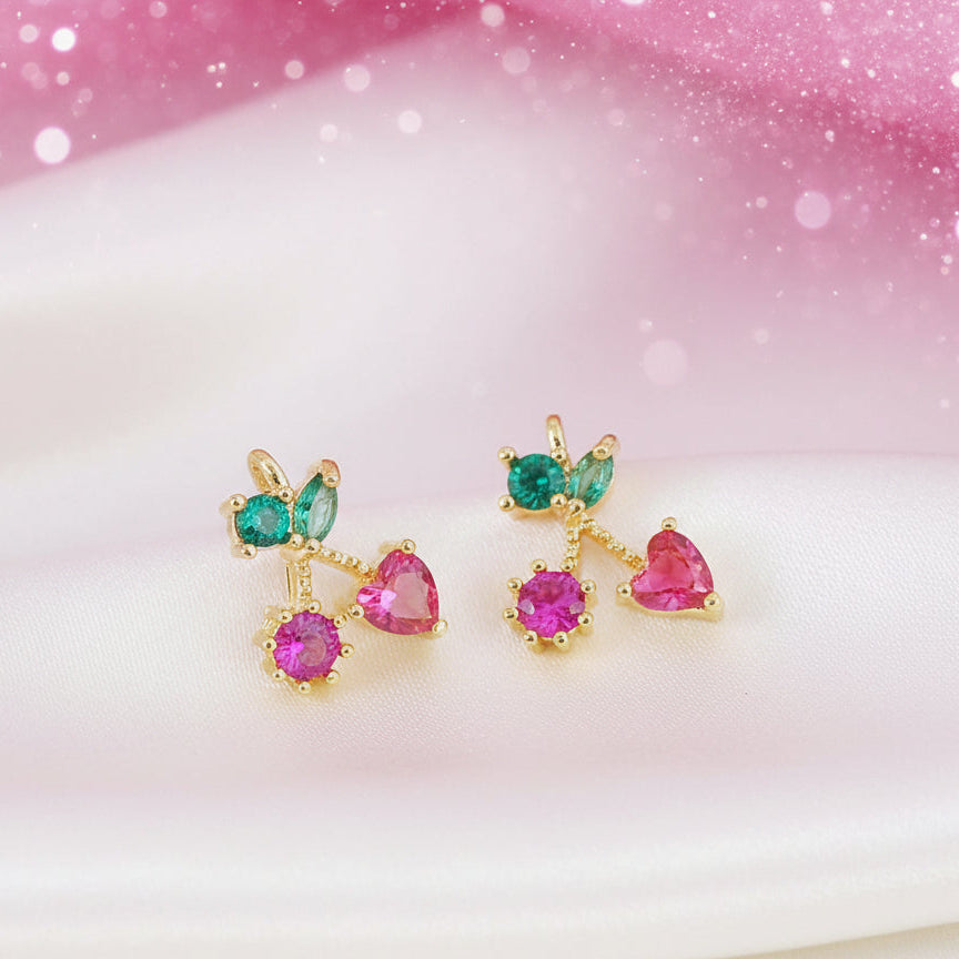 Petite Pink Cherry Heart Earrings with pink and green gemstones on a soft pink and white background