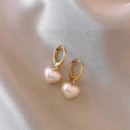 Iridescent Heart Drop Earrings with gold hoops on a soft fabric background