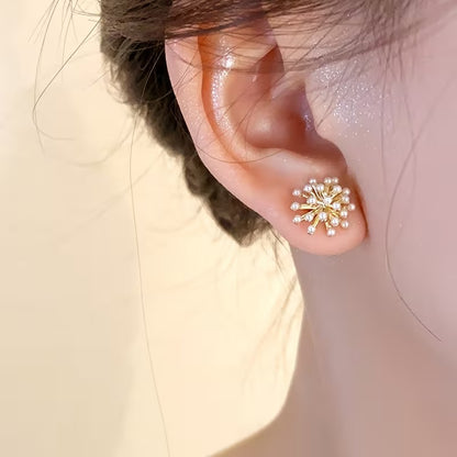 Close-up of an ear wearing a Gold Burst Pearl Earrings on a neutral background