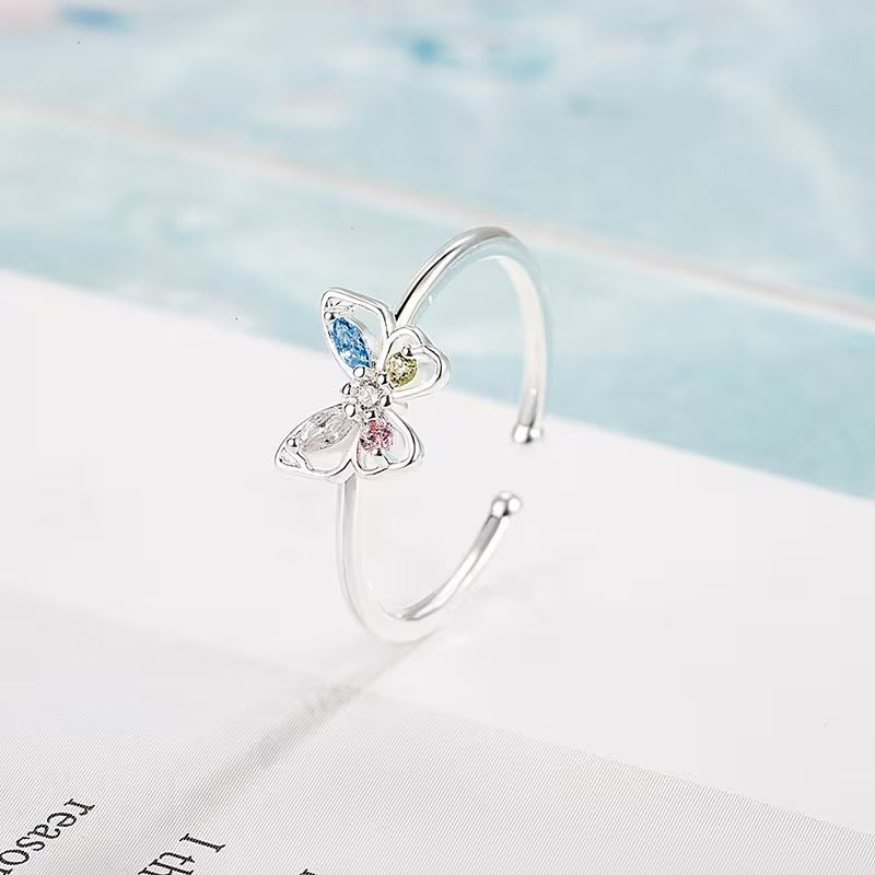 Pastel Butterfly Adjustable Ring on a light blue and white background