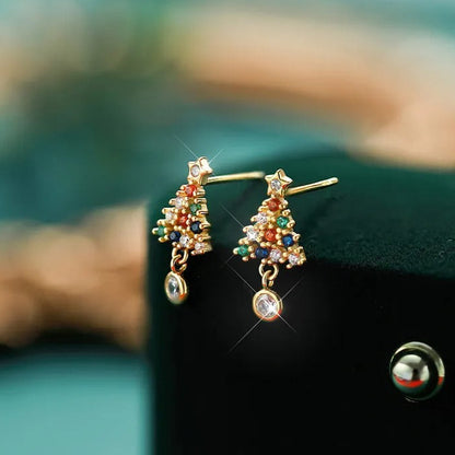 Twinkling Christmas Tree Earrings on a black surface