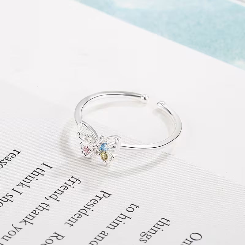 Pastel Butterfly Adjustable Ring with colorful gemstones on a white background