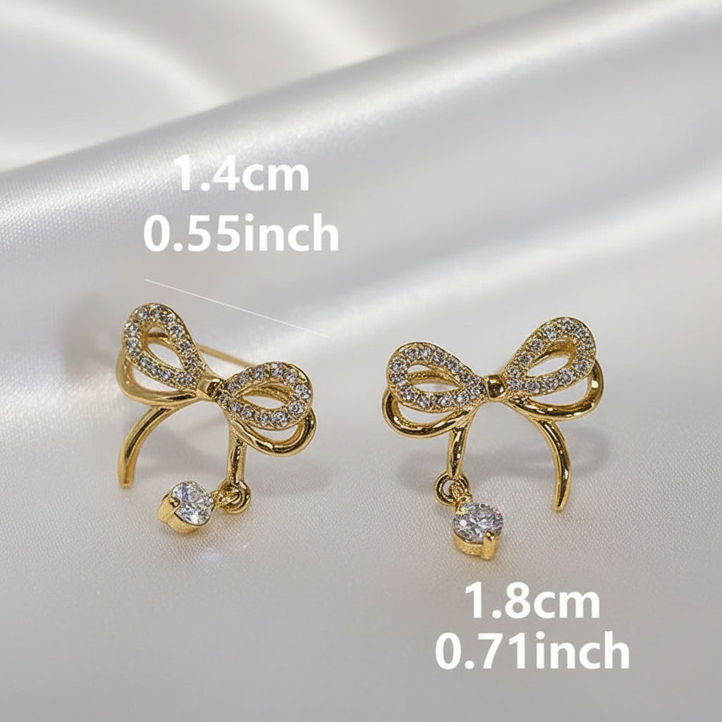 Sparkling Gold Crystal Bow Earrings with measurements on a reflective surface