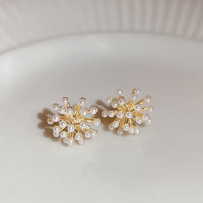 Gold Burst Pearl Earrings on a light gray background