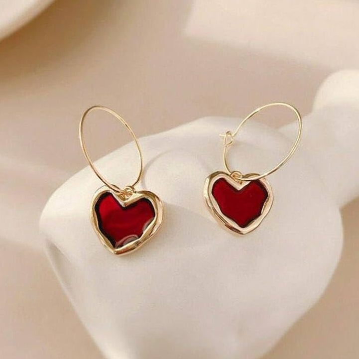 Ruby Heart Hoop Earrings with red centers on a white stand.