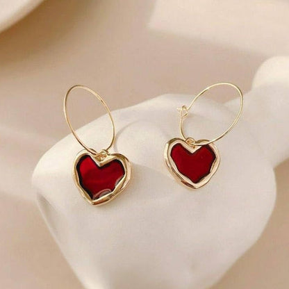 Ruby Heart Hoop Earrings with red centers on a white stand.