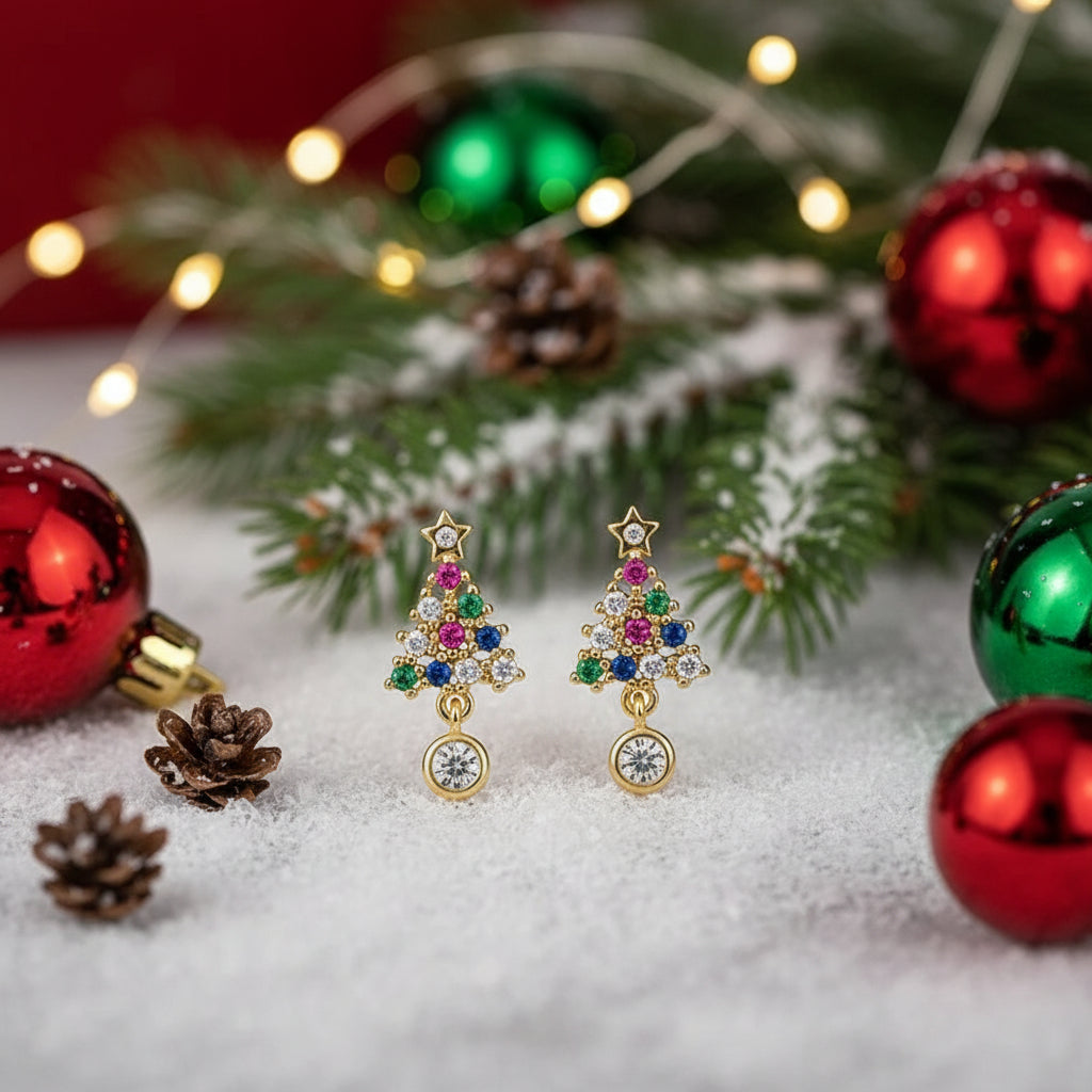 Twinkling Christmas Tree Earrings with gemstones on a snowy background with ornaments and lights.