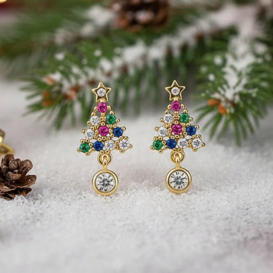 Twinkling Christmas Tree Earrings with colorful gemstones on a snowy background with pine branches.