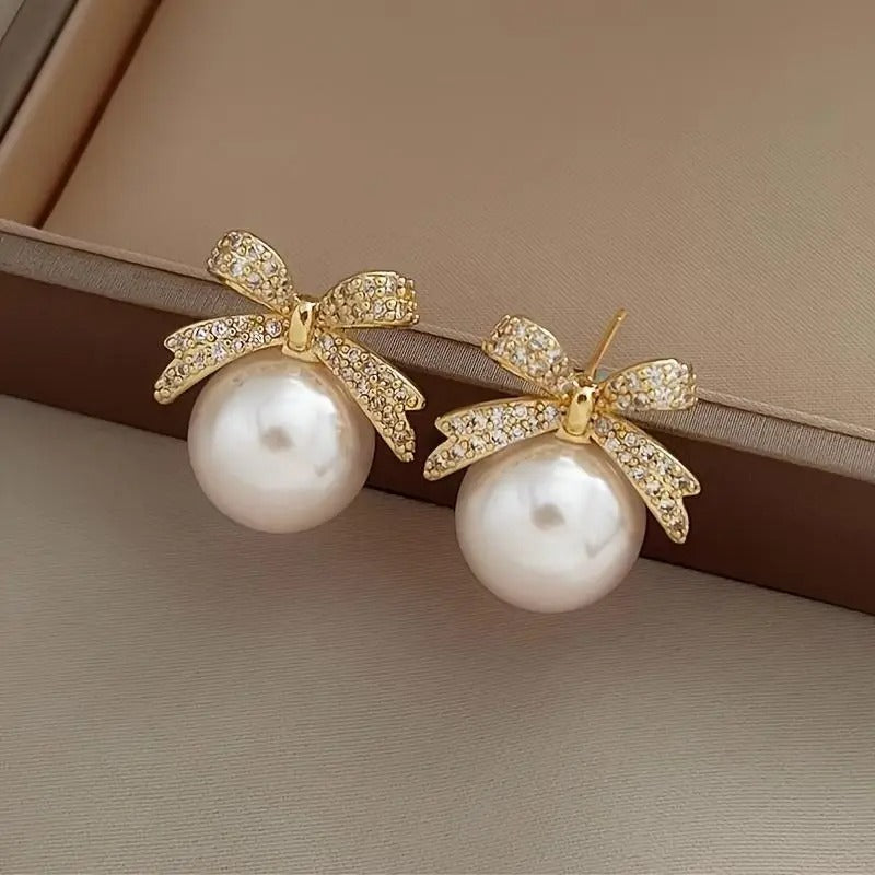 White Ornament Bow Earrings on a neutral background