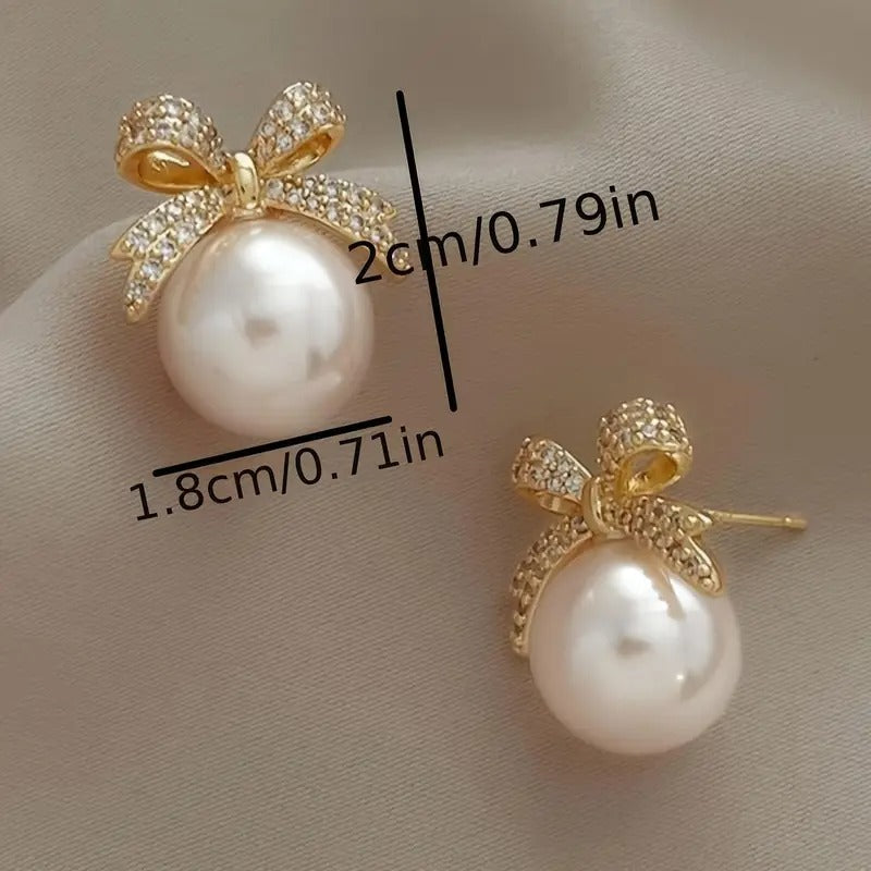 White Ornament Bow Earrings and measurements on a beige background