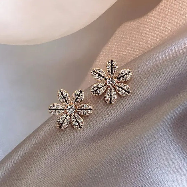 Black & Gold Rhinestone Flower Earrings on a soft fabric background