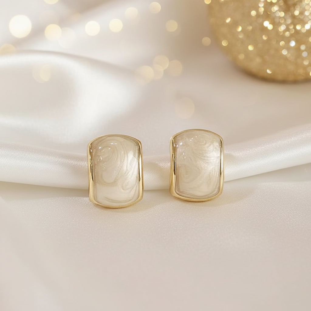 Gold-Trim Mother-of-Pearl Earrings on a white surface with a soft, blurred background