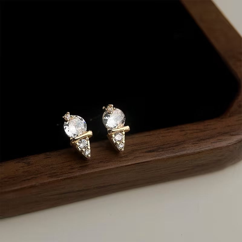 Mini Gold Ice Cream CZ Earrings on a dark surface.