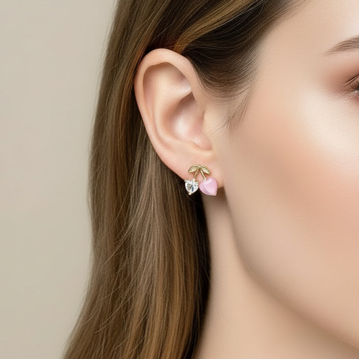 Close-up of a person wearing Pink Cherry & Crystal Heart Earrings.