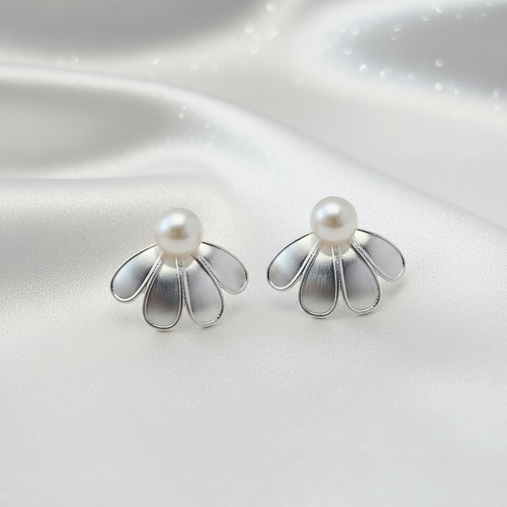 Silver Sculpted Petal Pearl Earrings with pearl centers on a reflective silver surface