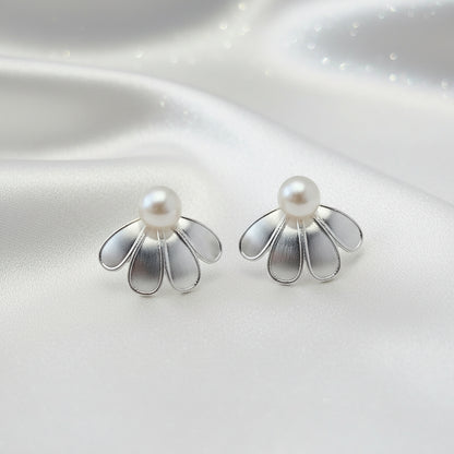 Silver Sculpted Petal Pearl Earrings with pearl centers on a reflective silver surface