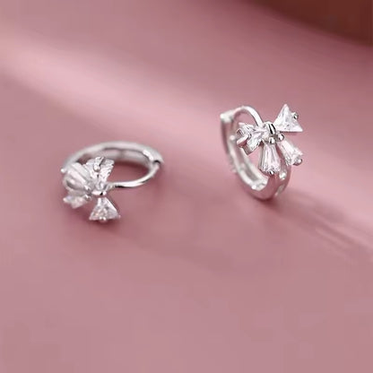 Tiny Crystal Ribbon Earrings on a pink background