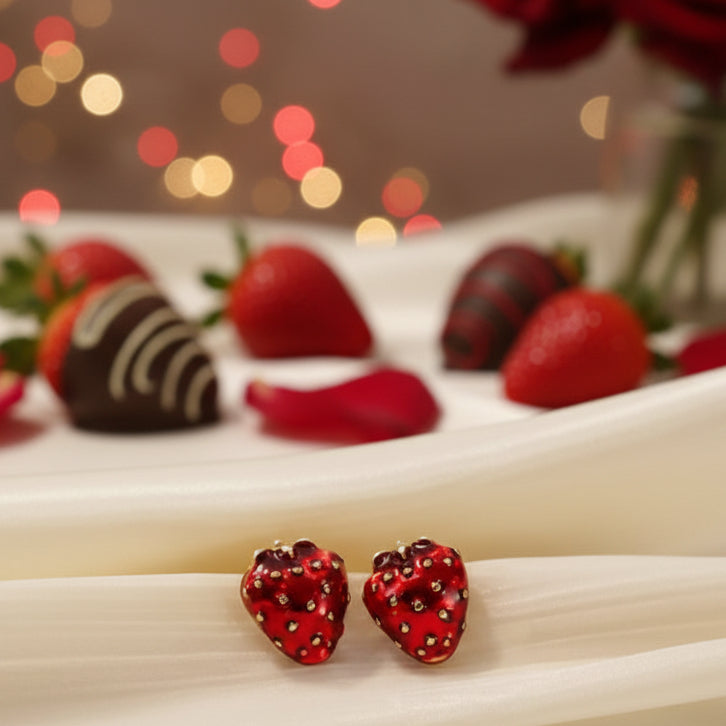 Ruby Red Strawberry Earrings on a beige fabric background