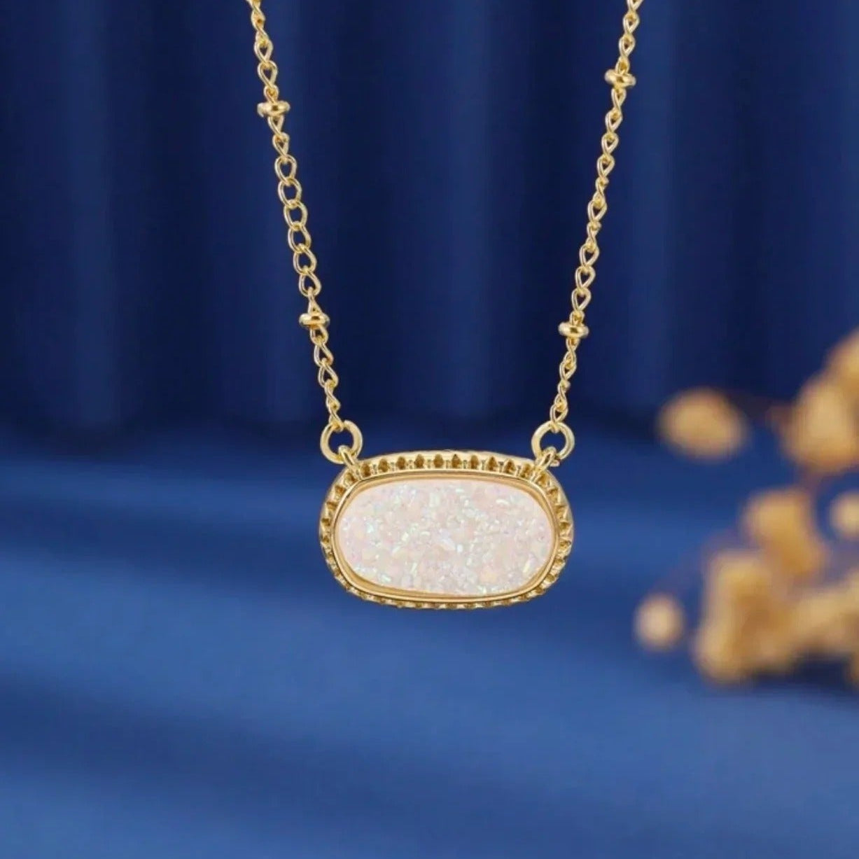 White Opal Druzy Glow Pendant Gold Necklace on a blue background