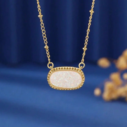 White Opal Druzy Glow Pendant Gold Necklace on a blue background