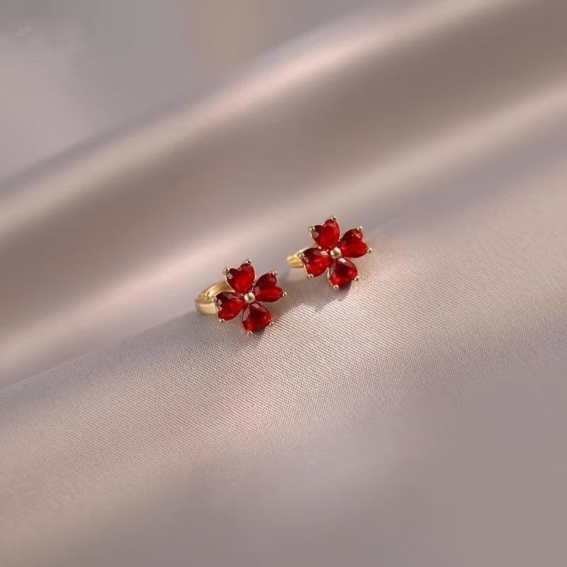 Pair of Ruby Red Flower Petal Hoop Earrings on a beige fabric background