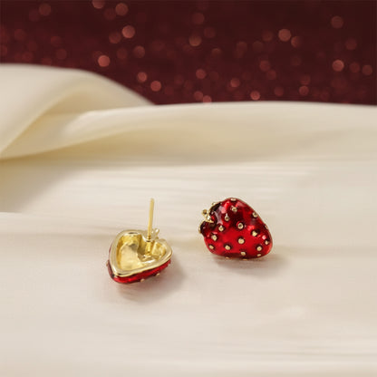 Ruby Red Strawberry Earrings on a white fabric background.