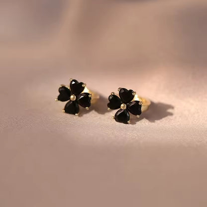Black Flower Petal Hoop Earrings with gold accents on a soft pink background