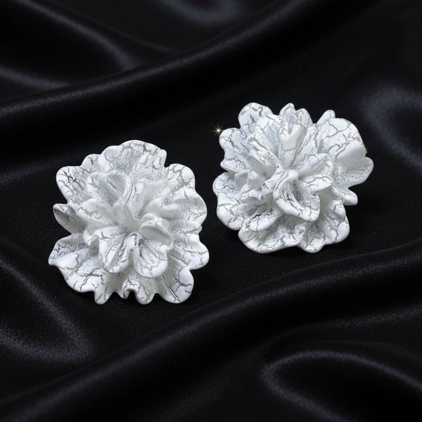 White Bloom Statement Stud Earrings on black satin fabric