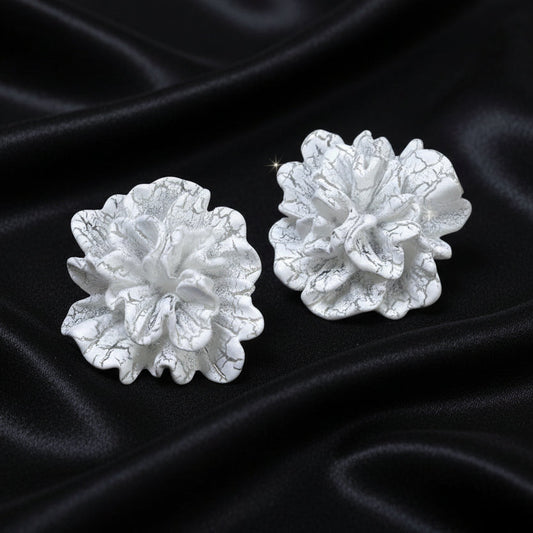 White Bloom Statement Stud Earrings on black satin fabric