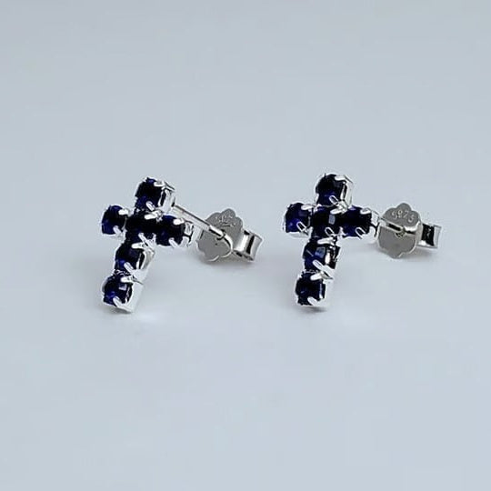Silver Mini Blue Crystal Cross Earrings with blue gemstones on a light gray background