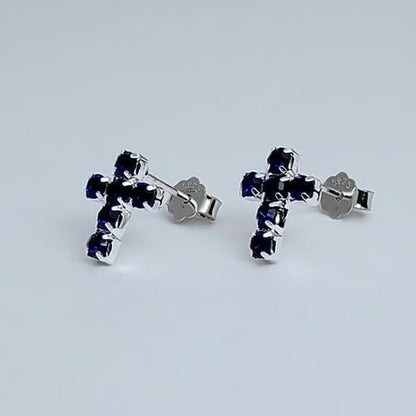 Silver Mini Blue Crystal Cross Earrings with blue gemstones on a light gray background