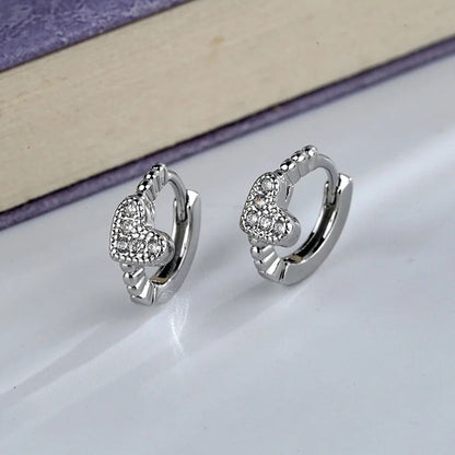 Silver Tiny Crystal Heart Earrings with heart designs on a light surface