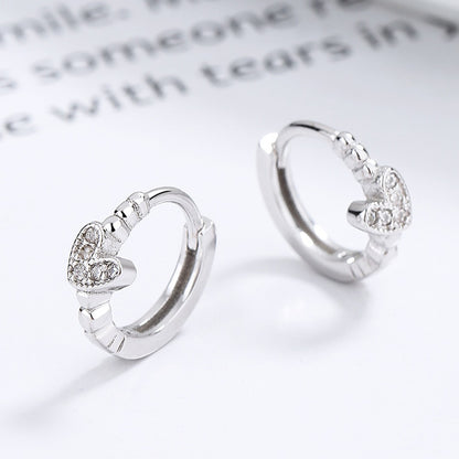 Silver Tiny Crystal Heart Earrings with heart-shaped designs on a light background