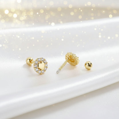 Tiny Gold Heart Halo Earrings on a white surface with a soft, blurred background