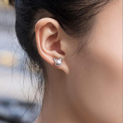 Close-up of a person wearing pearl cat  earrings with a blurred background