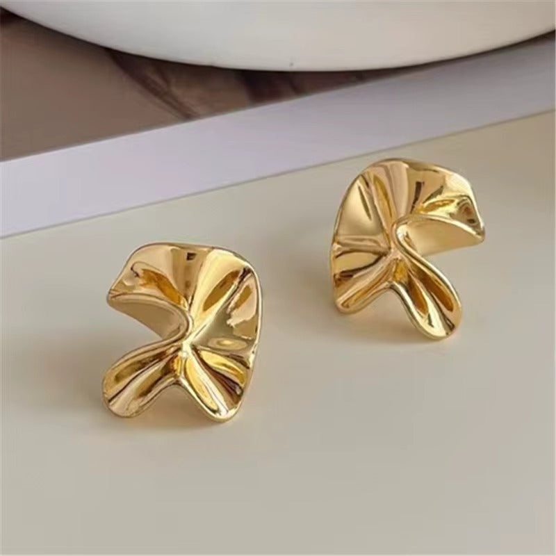 Gold earrings on a light background