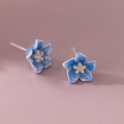 Pair of Blue Petal Blossom Earrings on a pink background
