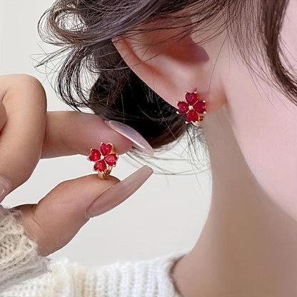 Close-up of a person Ruby Red Flower Petal Hoop Earrings with a blurred background