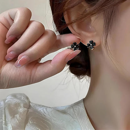 Close-up of a person wearing Black Flower Petal Hoop Earrings with a blurred background