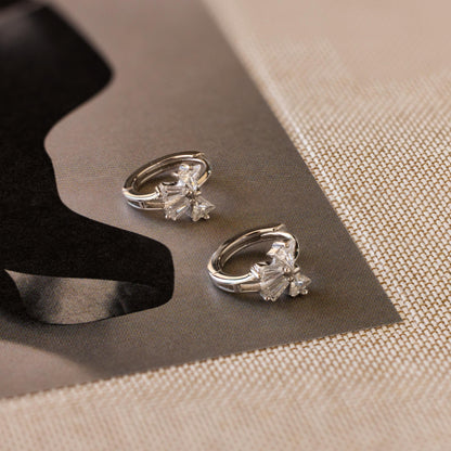 Tiny Crystal Ribbon Earrings on a textured surface